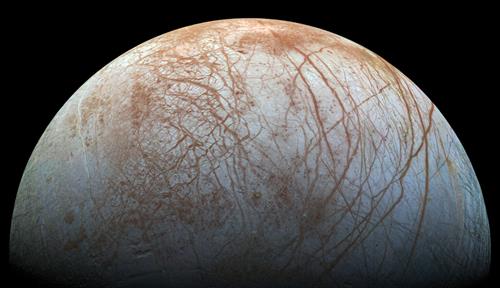 Processed color view of Jovian moon Europa showing cracks, ridges and disrupted terrain on the icy surface. From Galileo spacecraft.