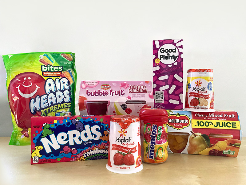 Photo of a display of packaged candy, yogurt and fruit, including AirHeads Xtremes Bites, rainbow Nerds, Bubble Fruit Cup Snacks and Yoplait strawberry yogurt.