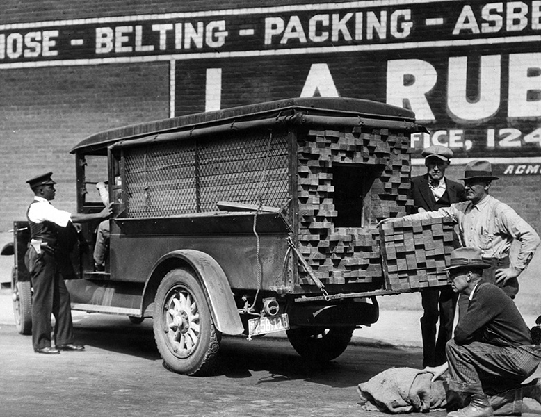 Vintage photograph of policemen searching a vehicle with a hidden compartment