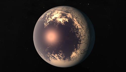 Artist’s rendering of a cold eyeball planet features a glowing orange “pupil” where the sun hits the planet, surrounded by dark blue ocean and then an icy white edge that recedes into darkness.