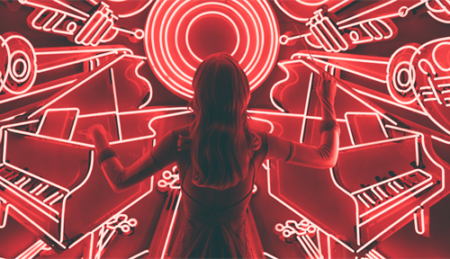 A woman holds a conductor's baton in front of red neon sculptures of various musical instruments. Human response to music has deep evolutionary roots and seems hard-wired in the brain, says cognitive psychologist Daniel Levitin in this Q&amp;A.