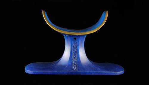 Photograph of a large blue glass headrest decorated with gold.