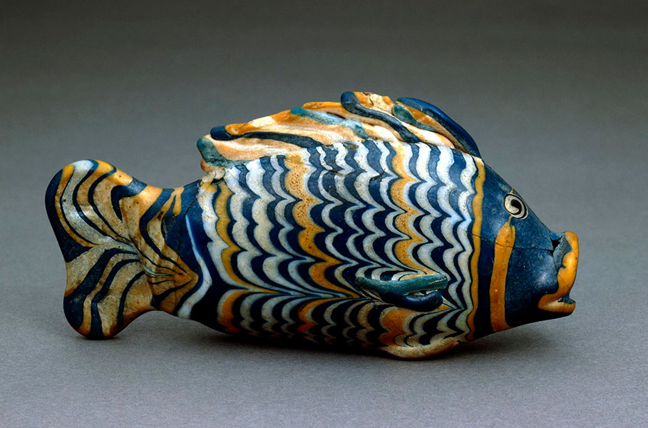 Photograph of a glass fish with wavy stripes of white, blue and yelow.