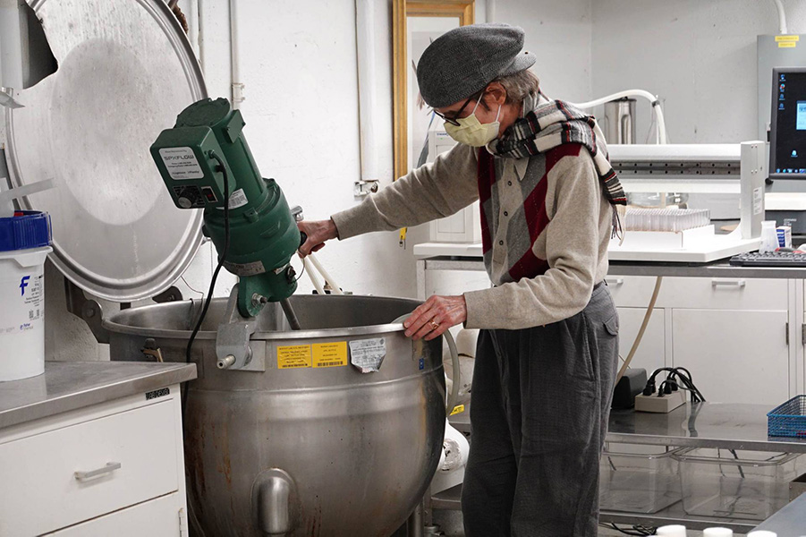 Gordon Gray stands at a large cauldron mixing a batch of fruit fly food.