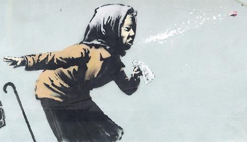 Street art by Banksy shows an old woman sneezing violently. Artwork was photographed in Totterdown, Bristol in the UK.