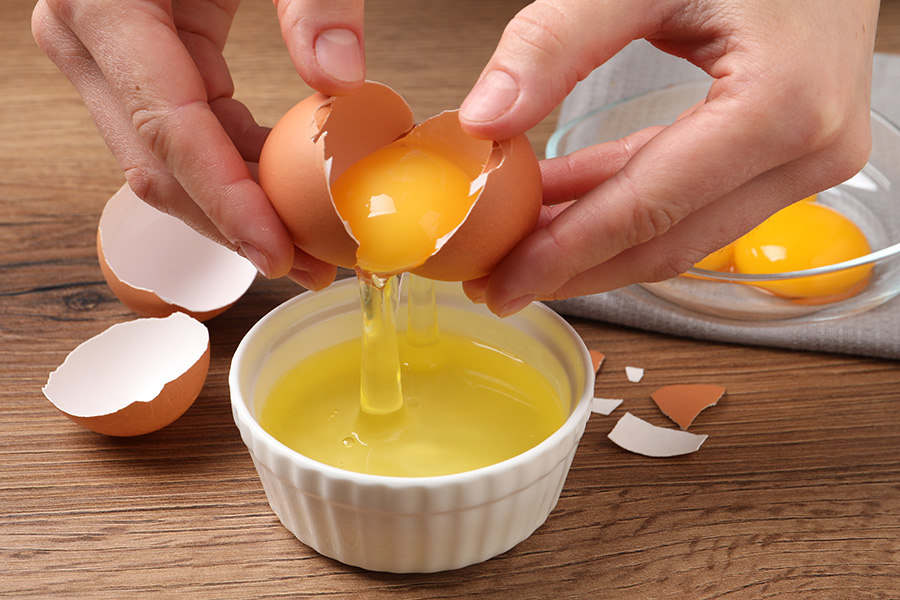 An egg being separated into yolk and white.